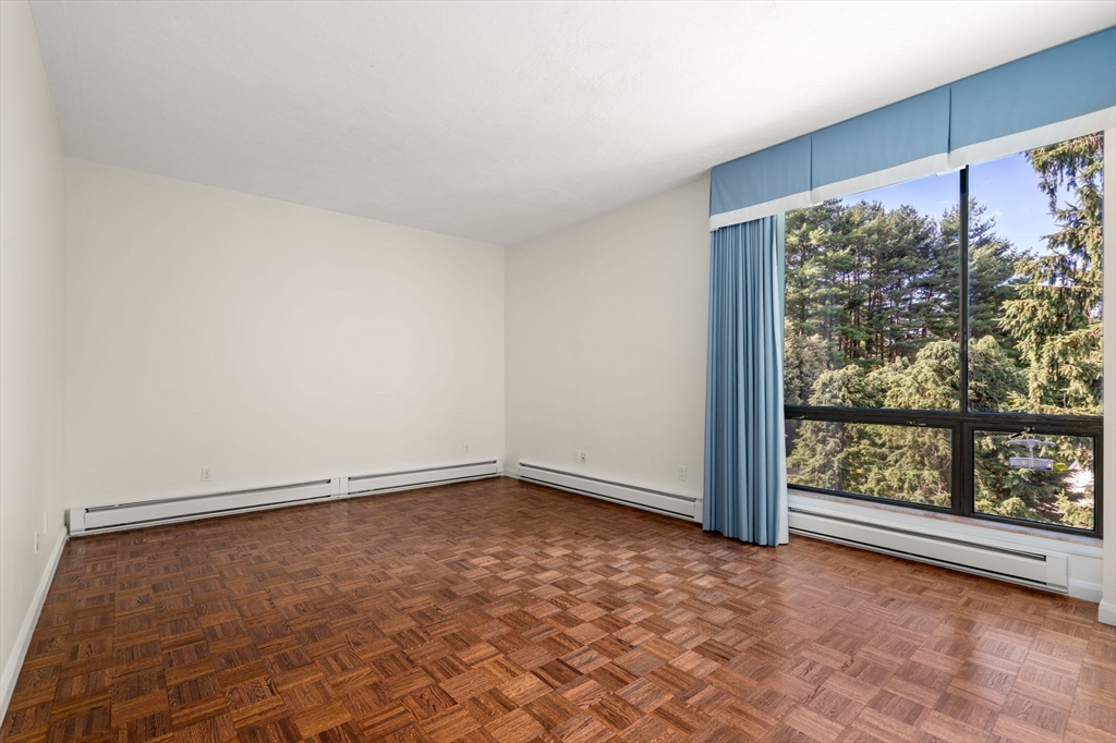 75 Grove Street, Unit 429 Wellesley, MA 02482 - Photo 9 of 22 wooden floor in an empty room with a window