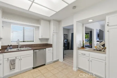 a kitchen with white cabinets and sink