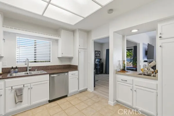 a kitchen with white cabinets and sink