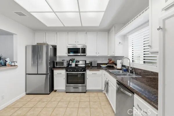 a kitchen with a sink a refrigerator and a stove top oven