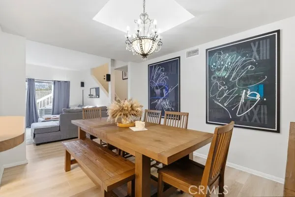 a view of a dining room with furniture a chandelier and wooden floor