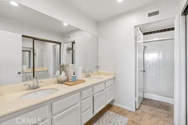 a en suite bathroom with double vanity and a mirror