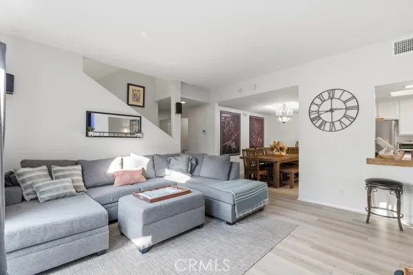 a living room with furniture a clock on wall and a window