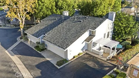 a view of a house with a yard and large tree