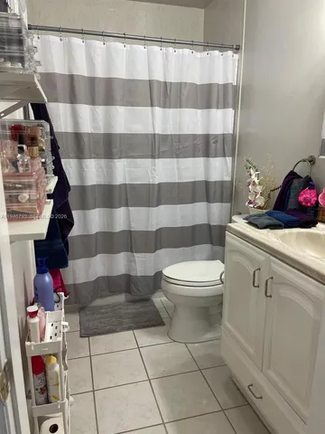 a bathroom with a toilet and a shower curtain