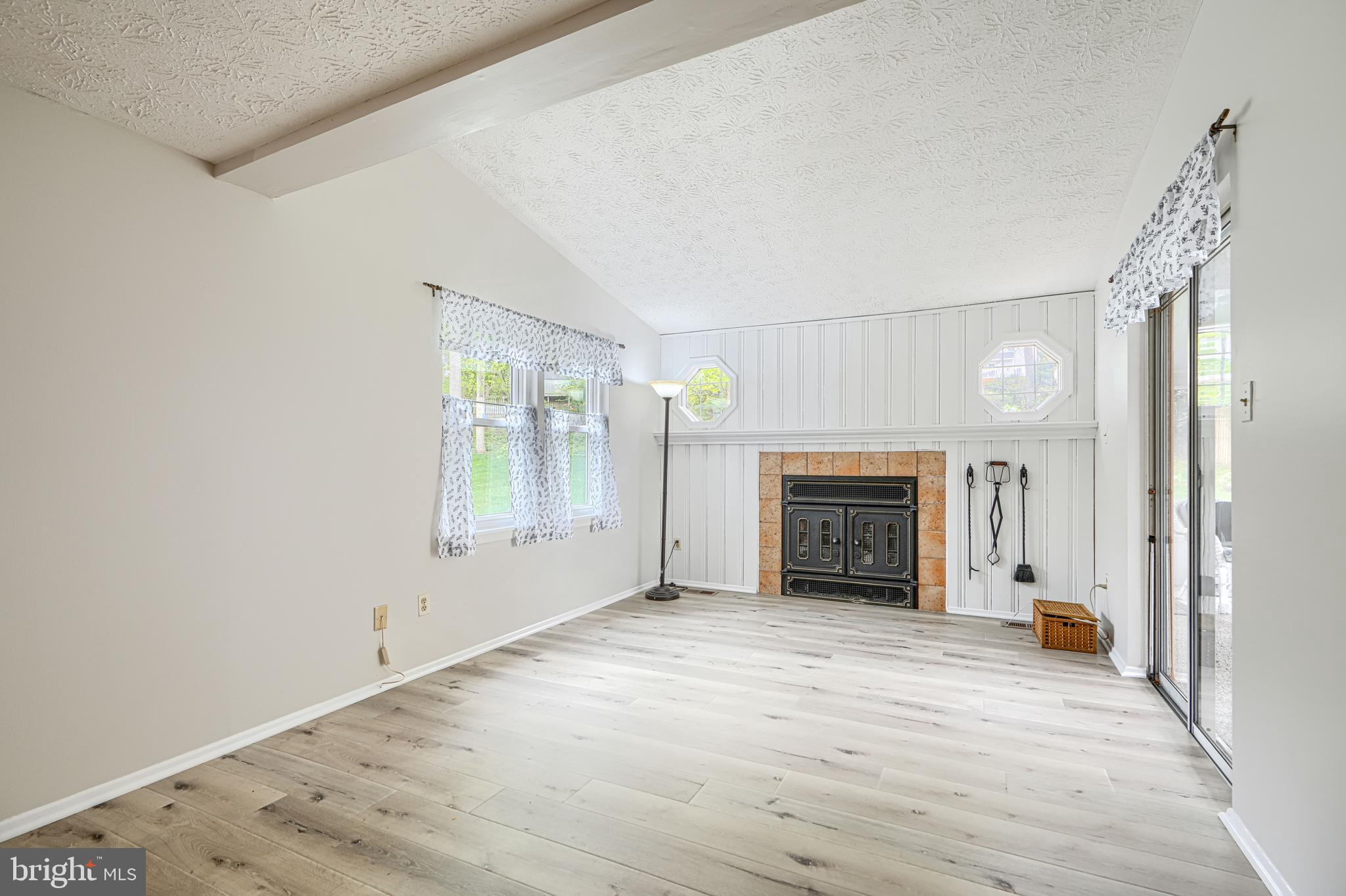 9405 Perglen Road Nottingham, MD 21236 - Photo 12 of 36 an empty room with fireplace and windows