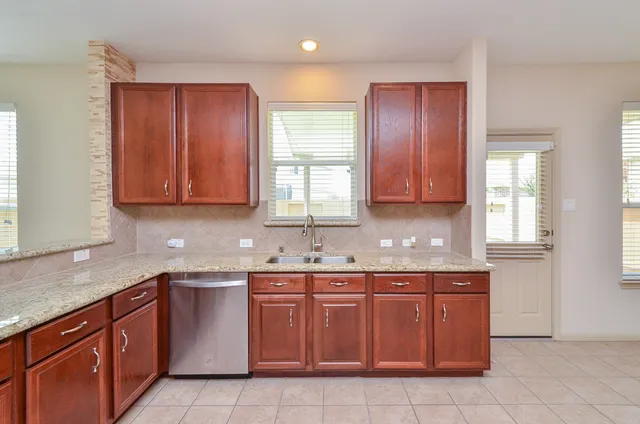 a kitchen with a sink window and cabinets