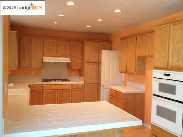 a kitchen with kitchen island a sink stainless steel appliances and cabinets