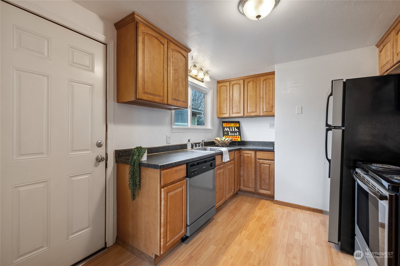 5037 South State Street Tacoma, WA 98409 - Photo 12 of 40 a kitchen with stainless steel appliances granite countertop a refrigerator stove and sink