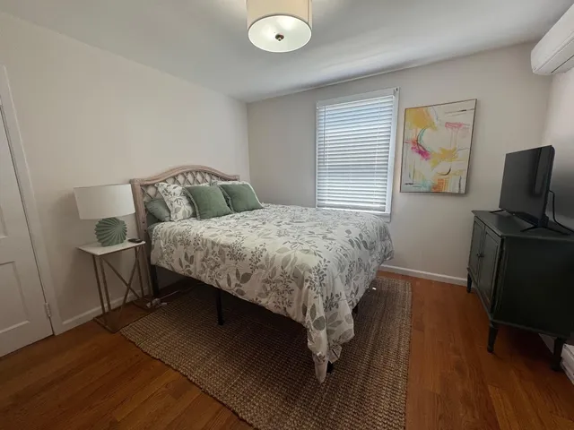 a bedroom with a bed and wooden floor