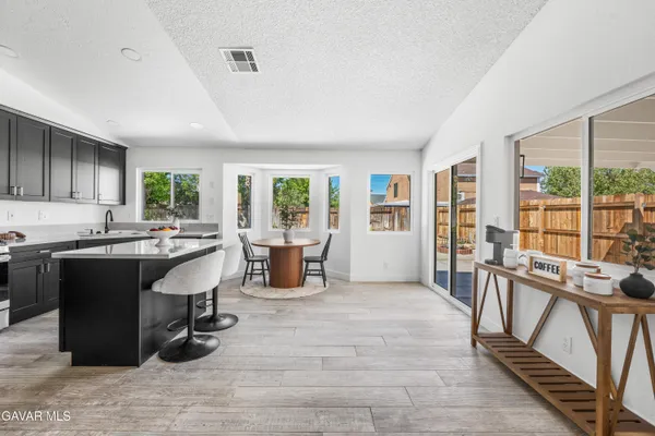 a living room with furniture a large window wooden floor and appliances