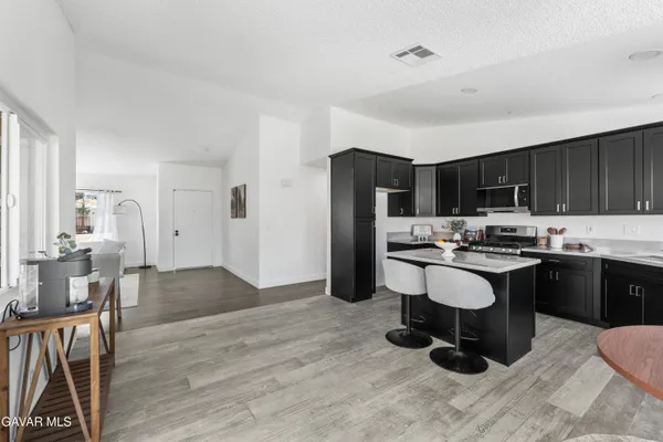 a kitchen with a sink a stove a refrigerator cabinets and dining table