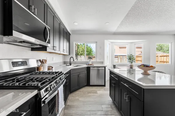 a kitchen with stainless steel appliances granite countertop a sink stove and cabinets