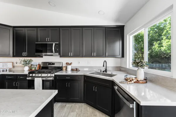 a kitchen with a sink and a stove top oven with wooden floor