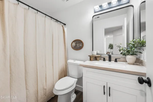 a bathroom with a toilet a sink and a mirror