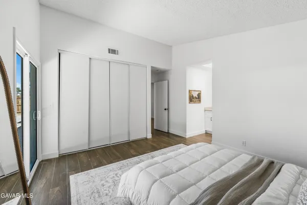 a bedroom with a bed and a large mirror