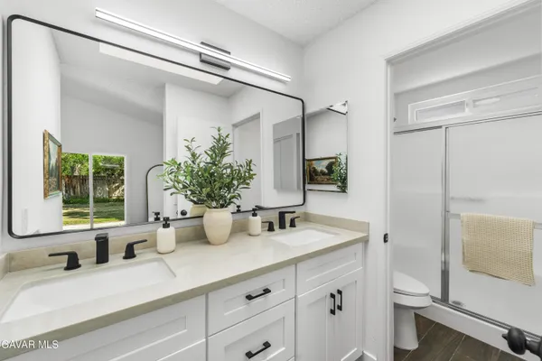 a bathroom with a double vanity sink toilet and shower