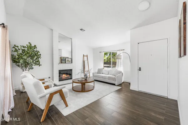 a living room with furniture a fireplace and a potted plant
