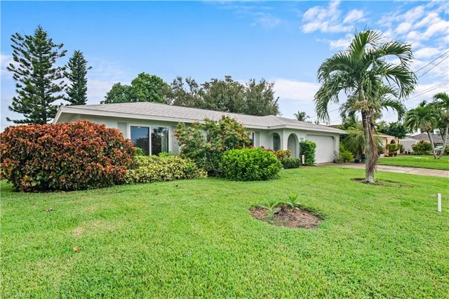 a view of a house with a yard and potted plants