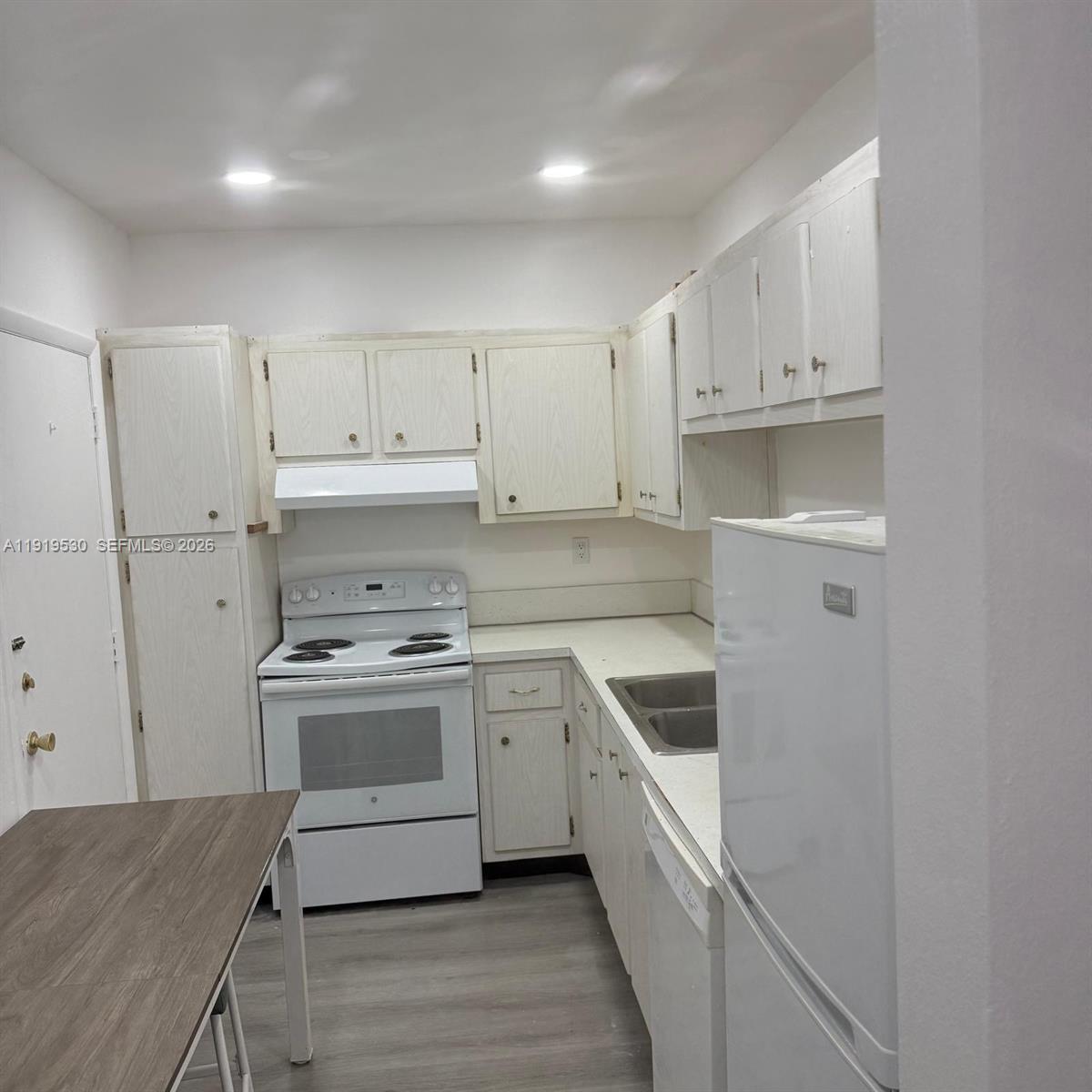 9159 Southwest 77th Avenue, Unit 211 Miami, FL 33156 - Photo 2 of 8 a kitchen with white cabinets and white appliances