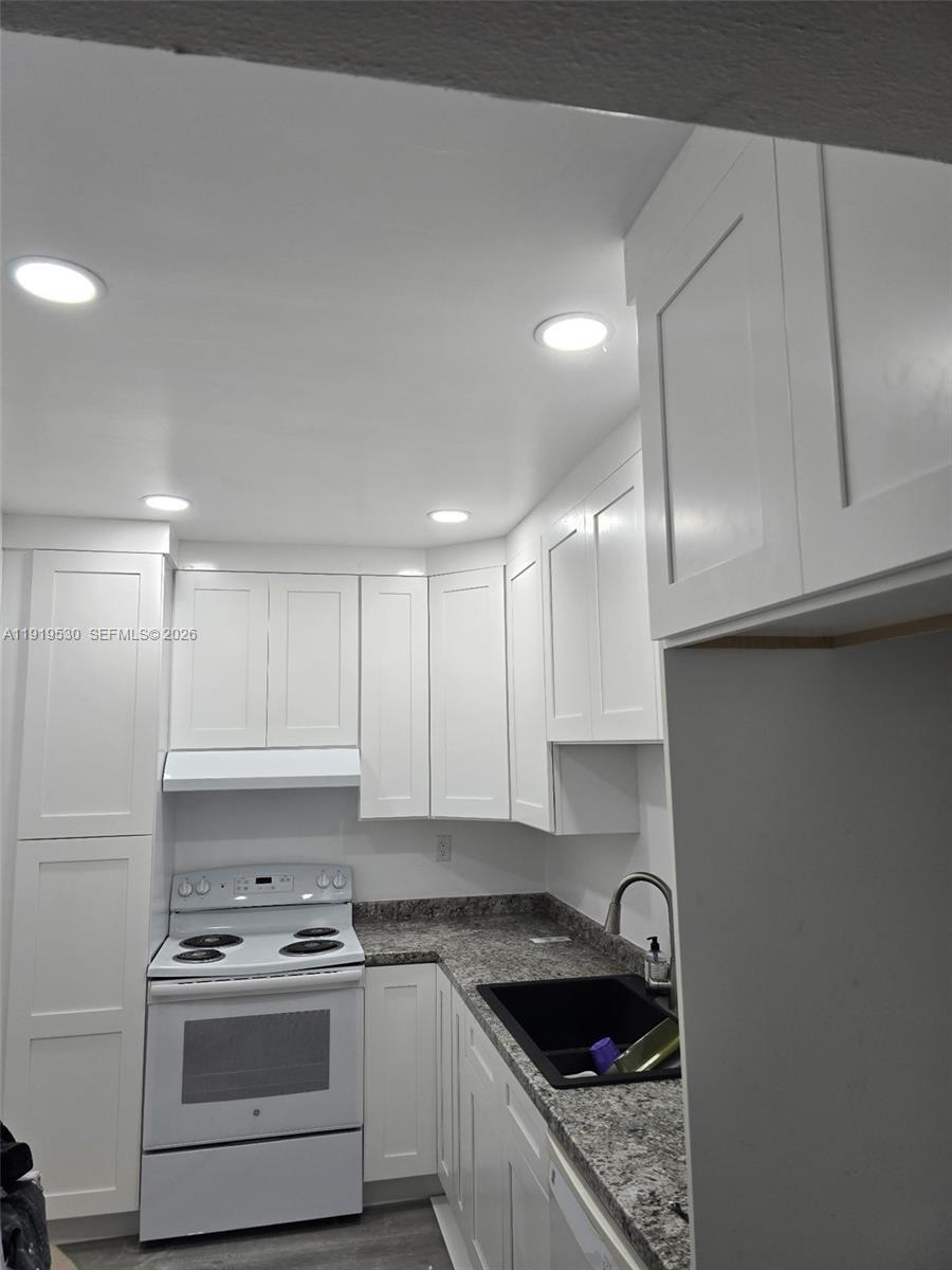 9159 Southwest 77th Avenue, Unit 211 Miami, FL 33156 - Photo 3 of 9 a kitchen with stainless steel appliances granite countertop a sink a stove and cabinets