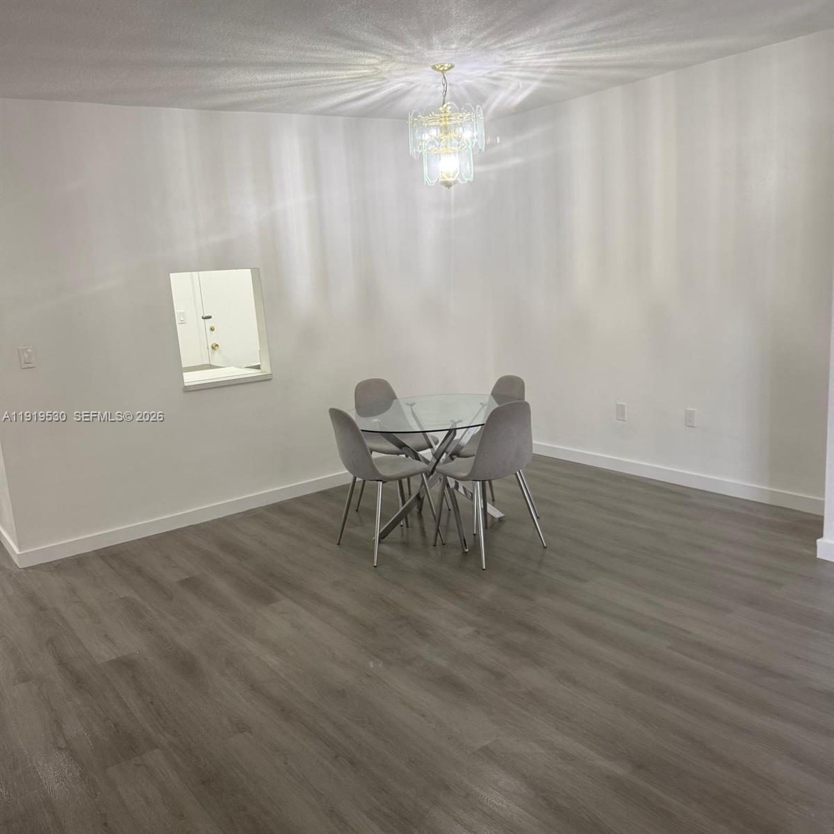 9159 Southwest 77th Avenue, Unit 211 Miami, FL 33156 - Photo 4 of 8 a dining room with furniture and chandelier