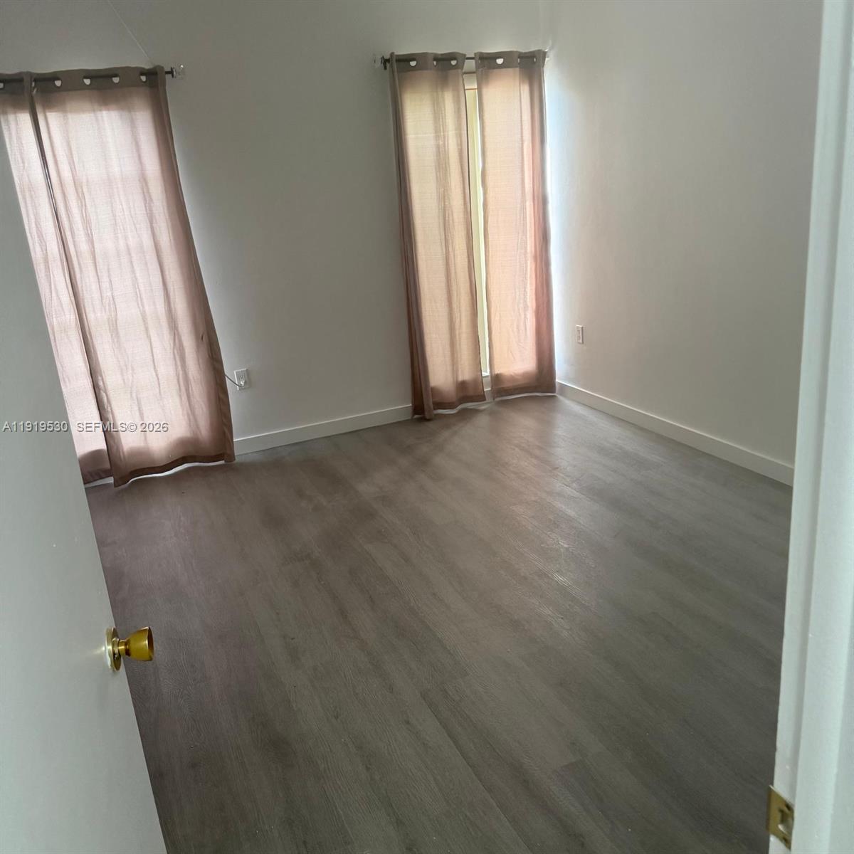 9159 Southwest 77th Avenue, Unit 211 Miami, FL 33156 - Photo 5 of 8 an empty room with window