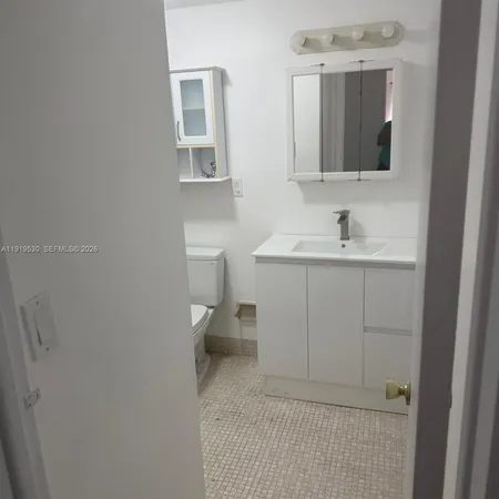 a bathroom with a sink toilet and mirror