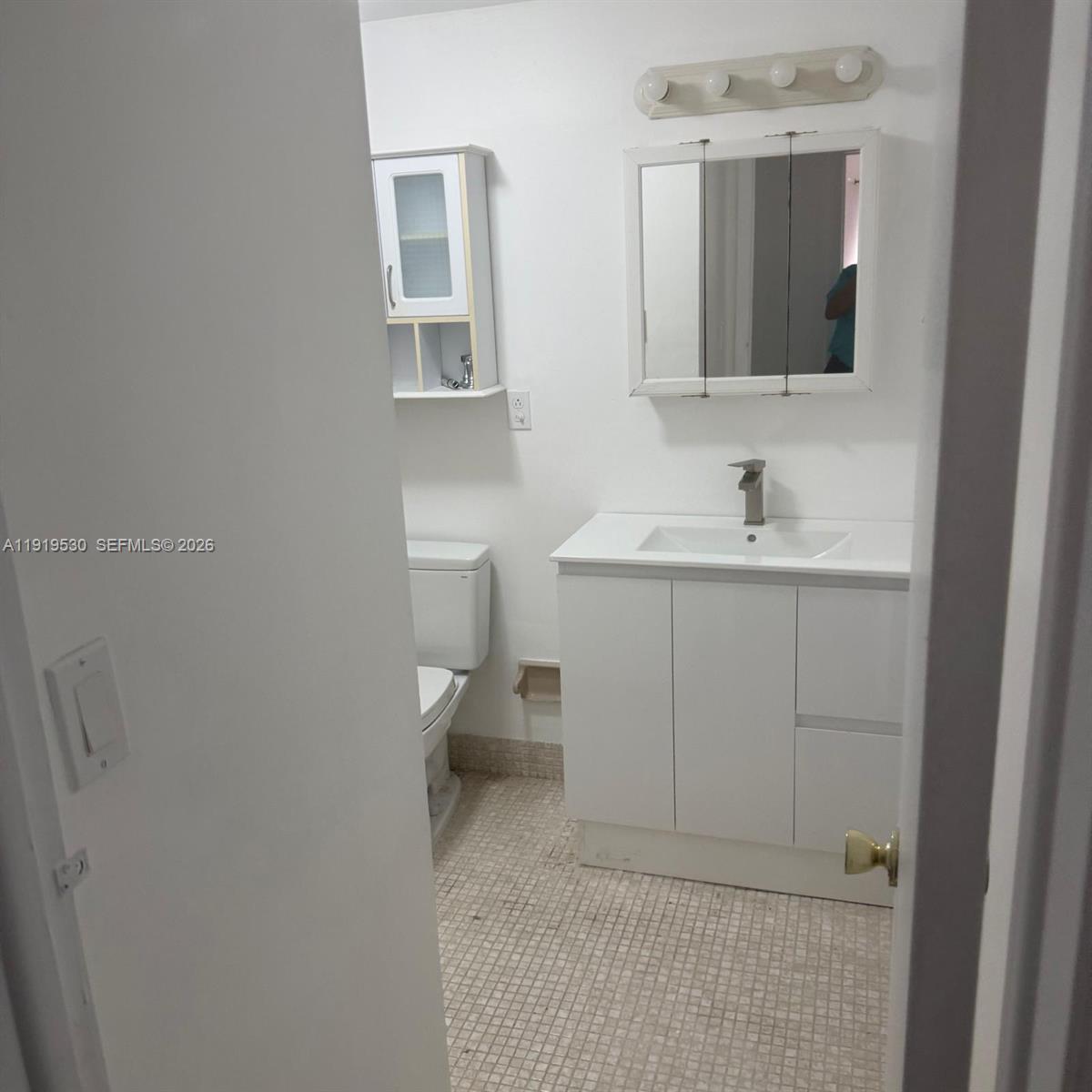 9159 Southwest 77th Avenue, Unit 211 Miami, FL 33156 - Photo 6 of 8 a bathroom with a sink toilet and mirror