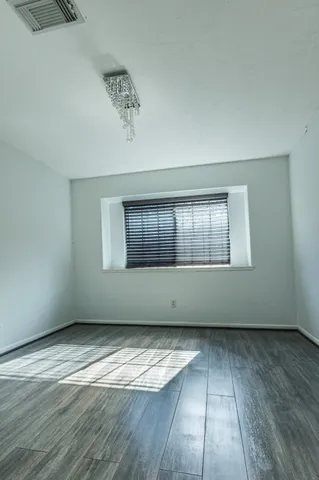 a view of an empty room and wooden floor