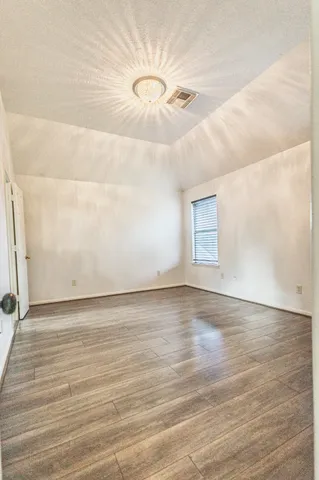 a view of a room with wooden floor and window