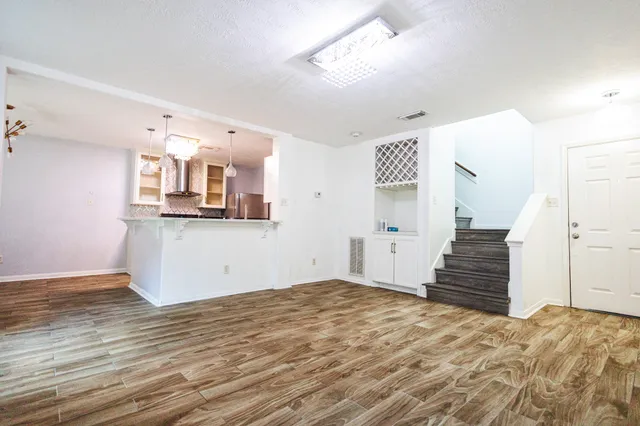 a view of a kitchen with wooden floor and staircase