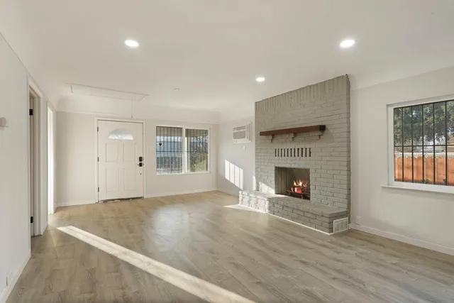 an empty room with windows and a fireplace