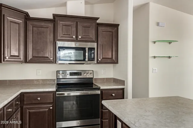 a kitchen with stainless steel appliances granite countertop a stove microwave and sink