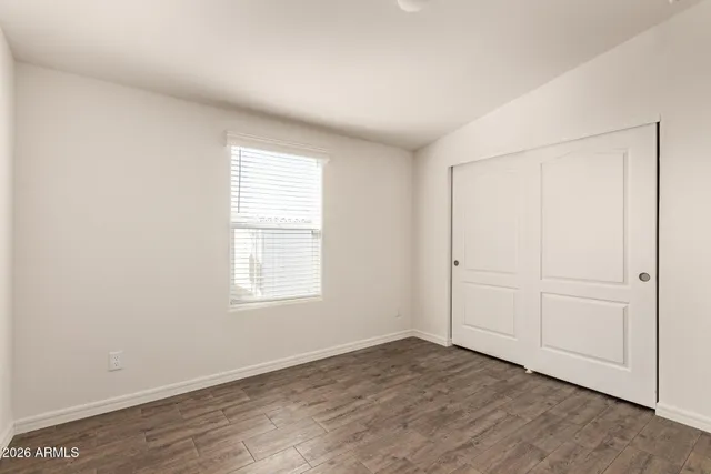 an empty room with wooden floor and window
