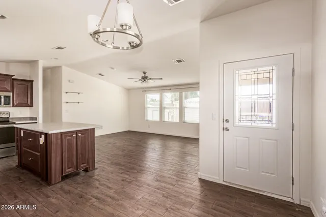 a view of an empty room with window and wooden floor