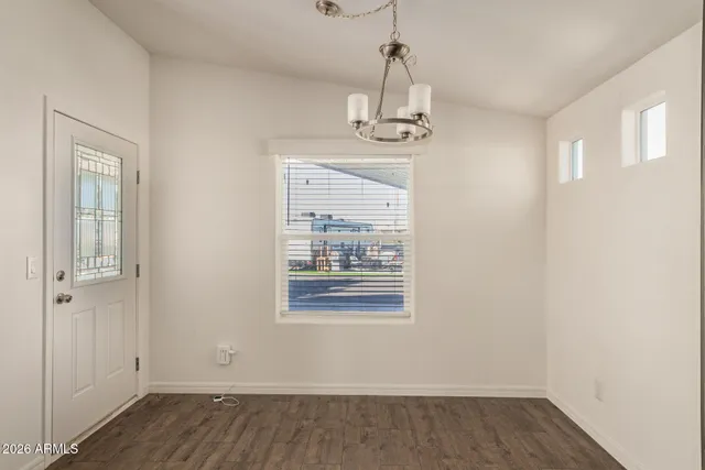 a view of empty room with wooden floor and window