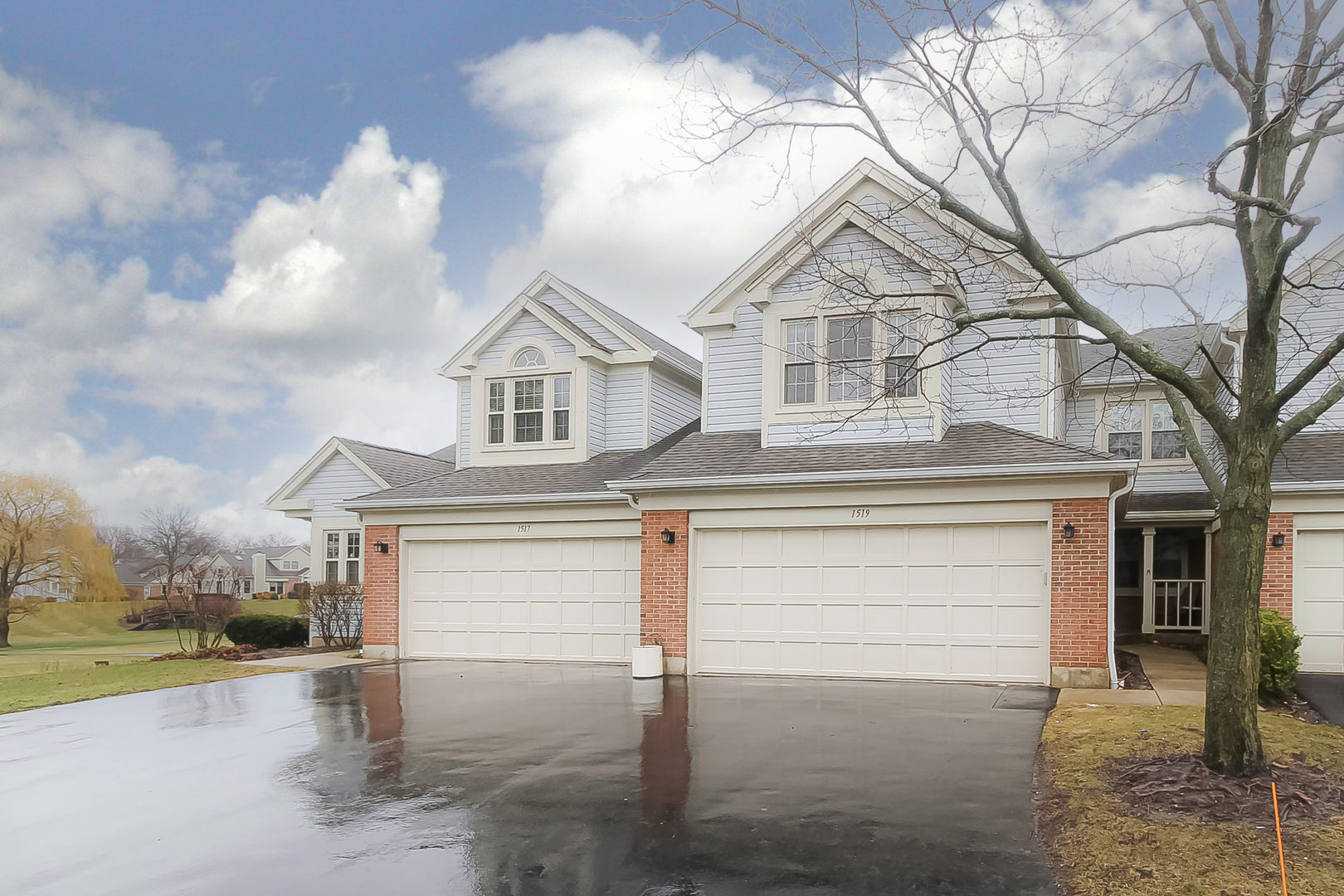 a view of a house with a large tree and a yard