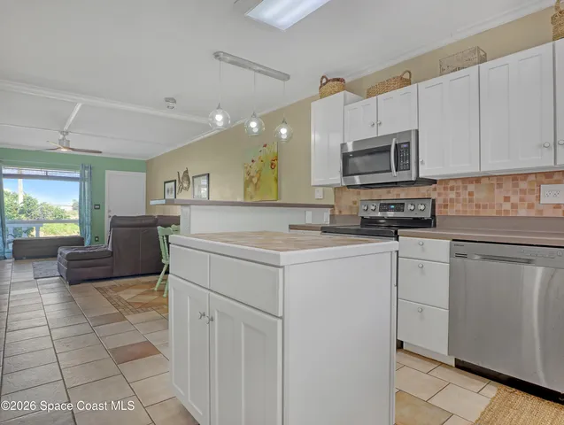 a kitchen with cabinets appliances a sink and a counter top space