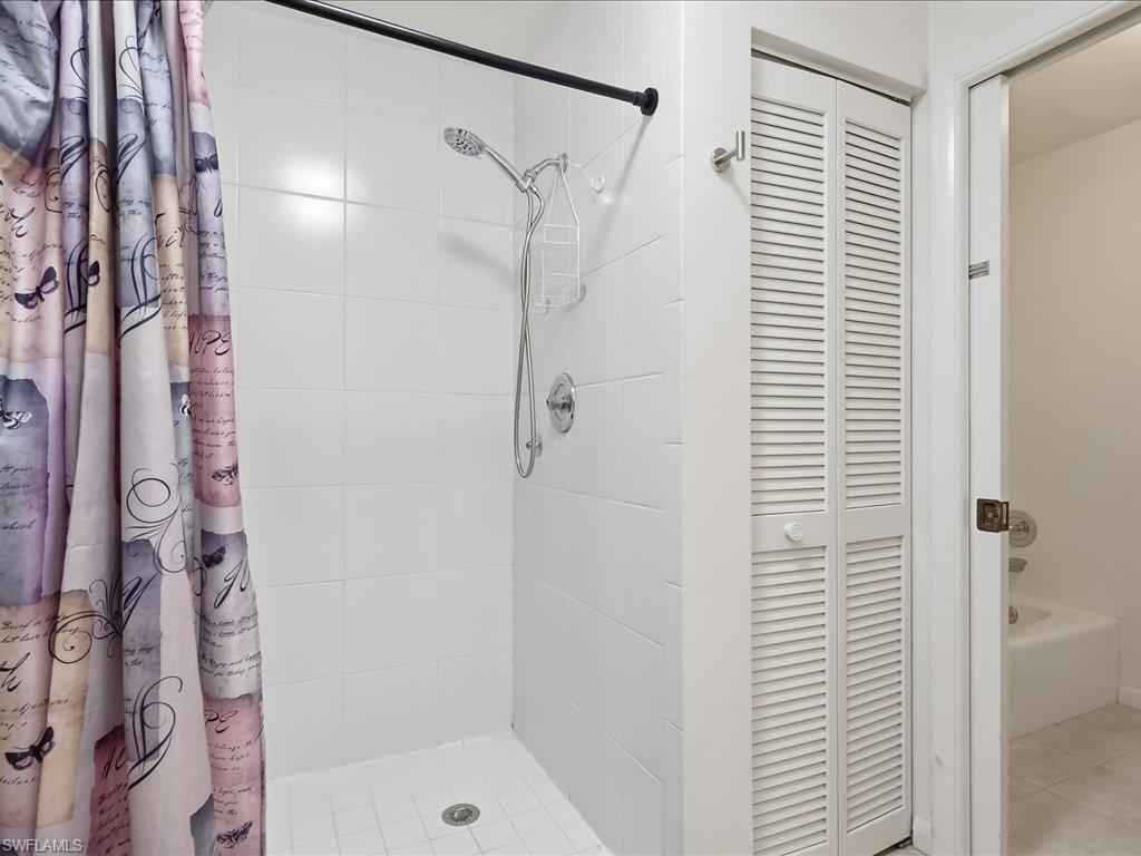 1833 Courtyard Way, Unit E105 Naples, FL 34112 - Photo 11 of 28 Full bathroom with a stall shower and a closet