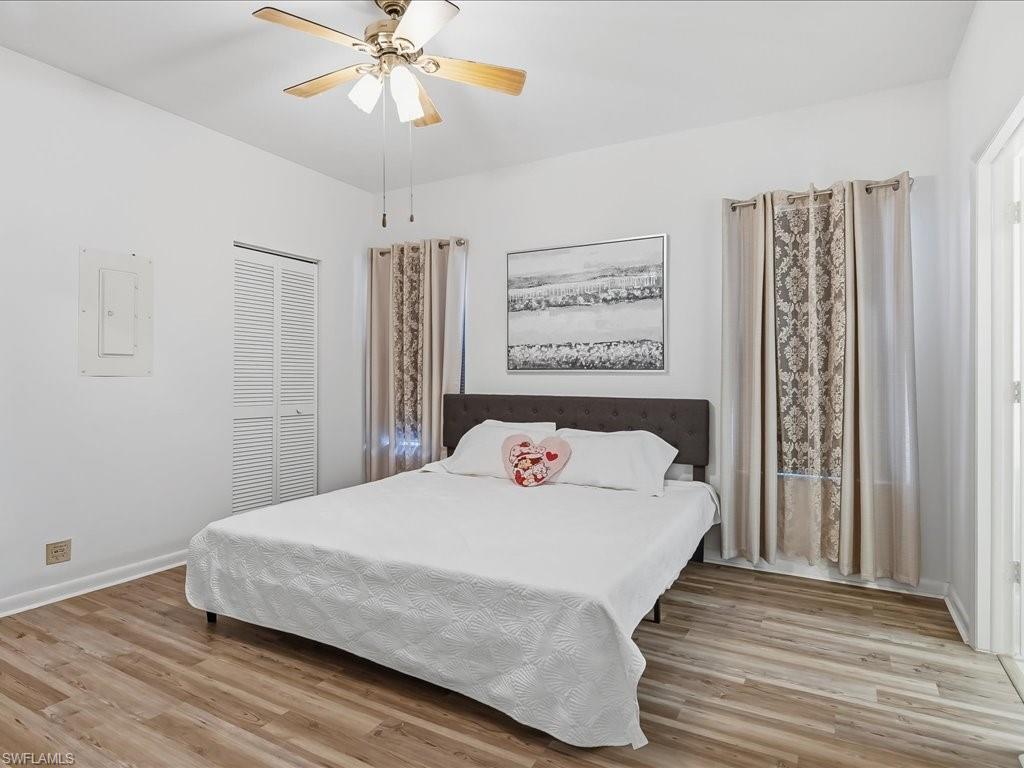 1833 Courtyard Way, Unit E105 Naples, FL 34112 - Photo 13 of 28 Bedroom with light wood-style floors, electric panel, ceiling fan, and a closet