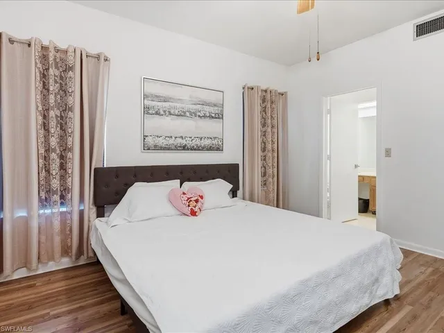 a bedroom with a large bed and a chandelier