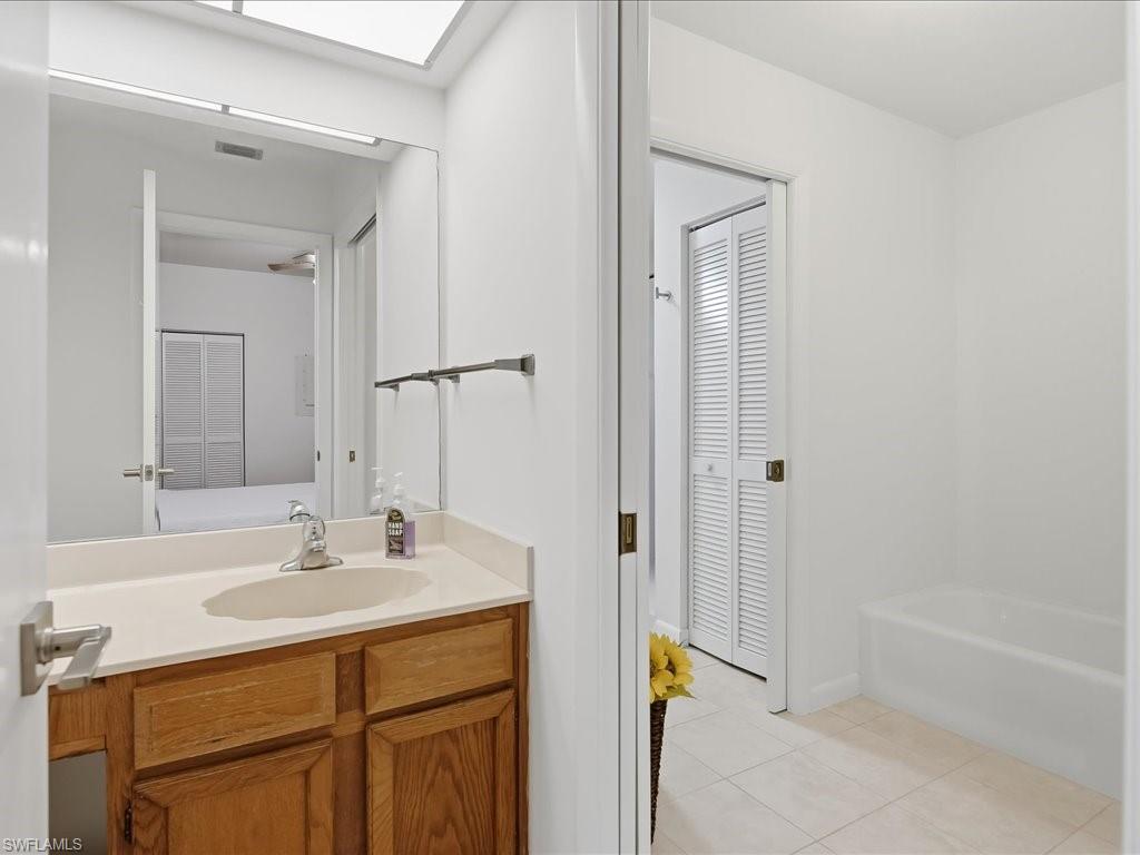 1833 Courtyard Way, Unit E105 Naples, FL 34112 - Photo 16 of 28 Full bath with vanity, light tile patterned floors, and a closet