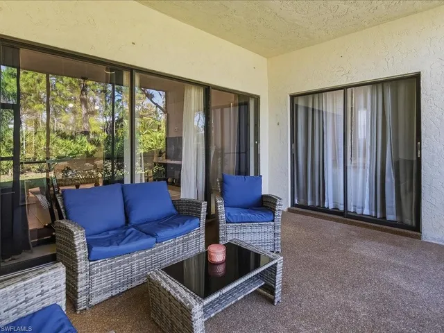 a living room with furniture and a floor to ceiling window