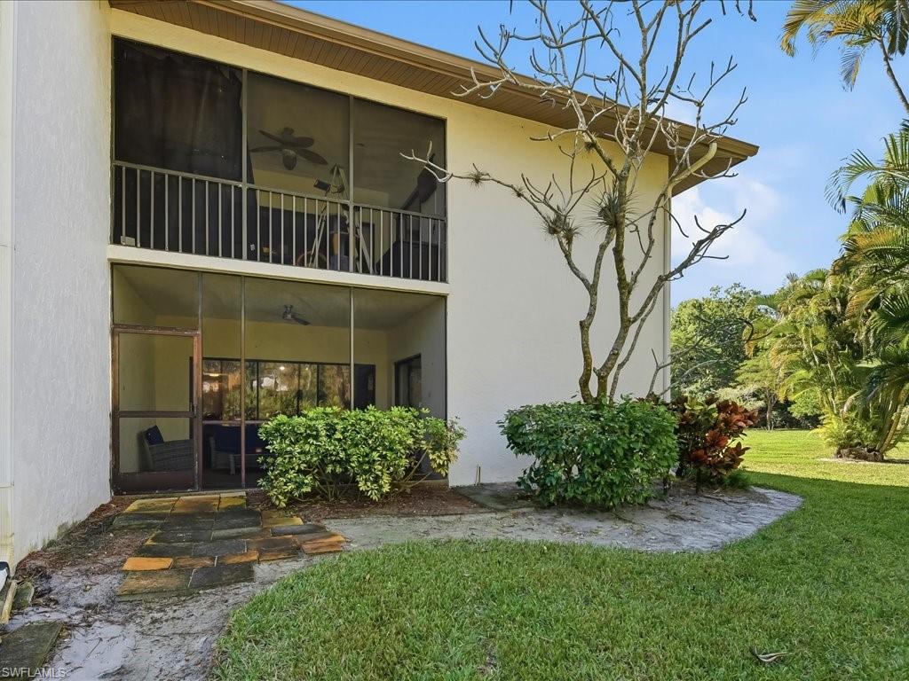 1833 Courtyard Way, Unit E105 Naples, FL 34112 - Photo 20 of 28 Rear view of house featuring a balcony, a sunroom, a yard, stucco siding, and ceiling fan