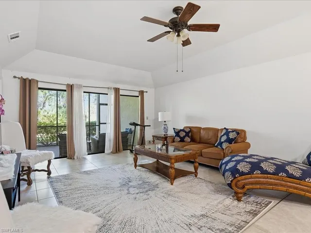 a living room with furniture and a ceiling fan