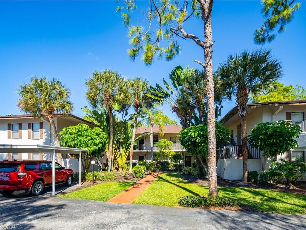 1833 Courtyard Way, Unit E105 Naples, FL 34112 - Photo 28 of 28 View of front of house with stucco siding and a front yard