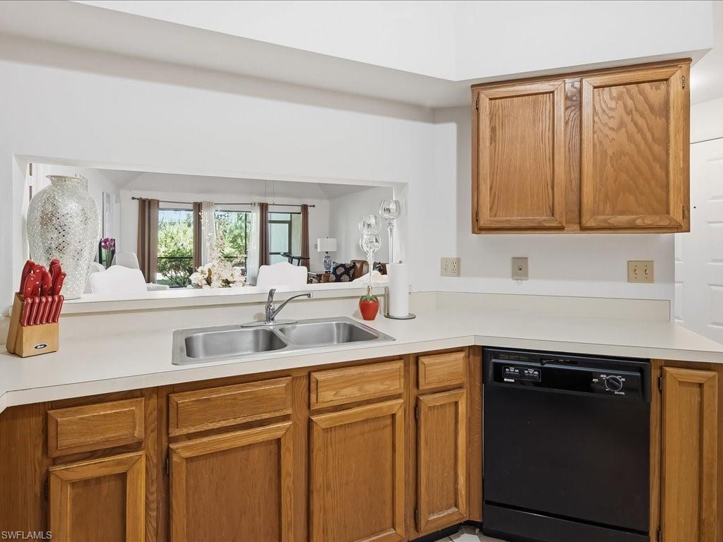 1833 Courtyard Way, Unit E105 Naples, FL 34112 - Photo 6 of 28 Kitchen featuring dishwasher, light countertops, brown cabinetry, and a peninsula
