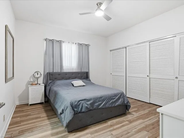 a bedroom with a large bed and wooden floor