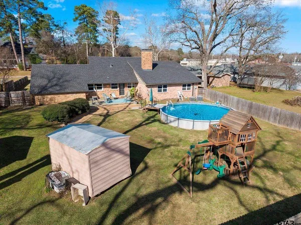 an aerial view of a house with swimming pool and furniture